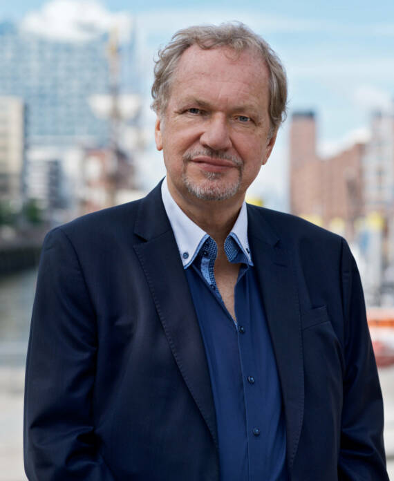 Ein Portrait von Professor Jens Michow (Branchen Experte & Anwalt Medien & Live Entertainment Recht) mit der Hafencity im Hintergrund